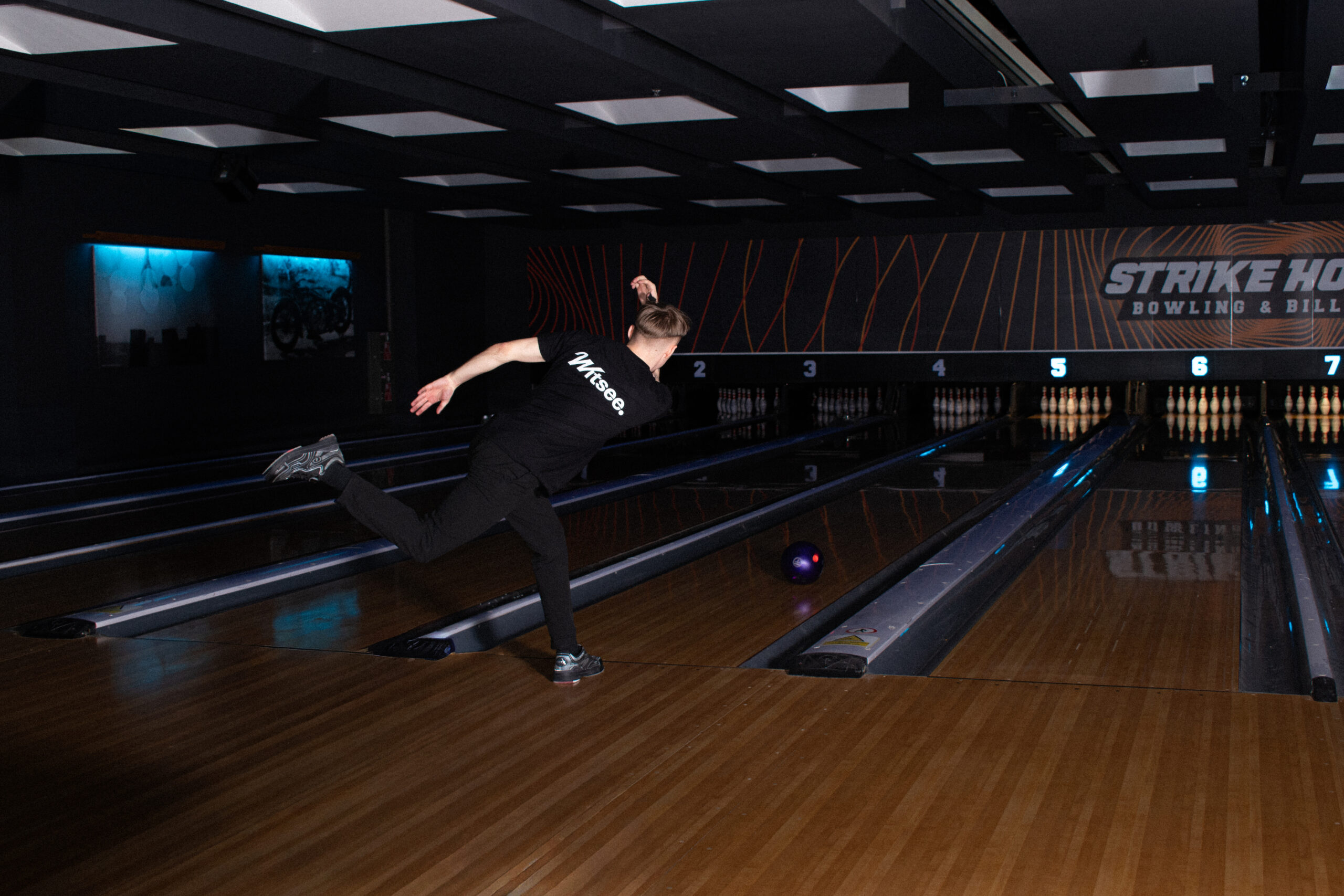 Bowler throwing a shot while wearing a Witsee shirt